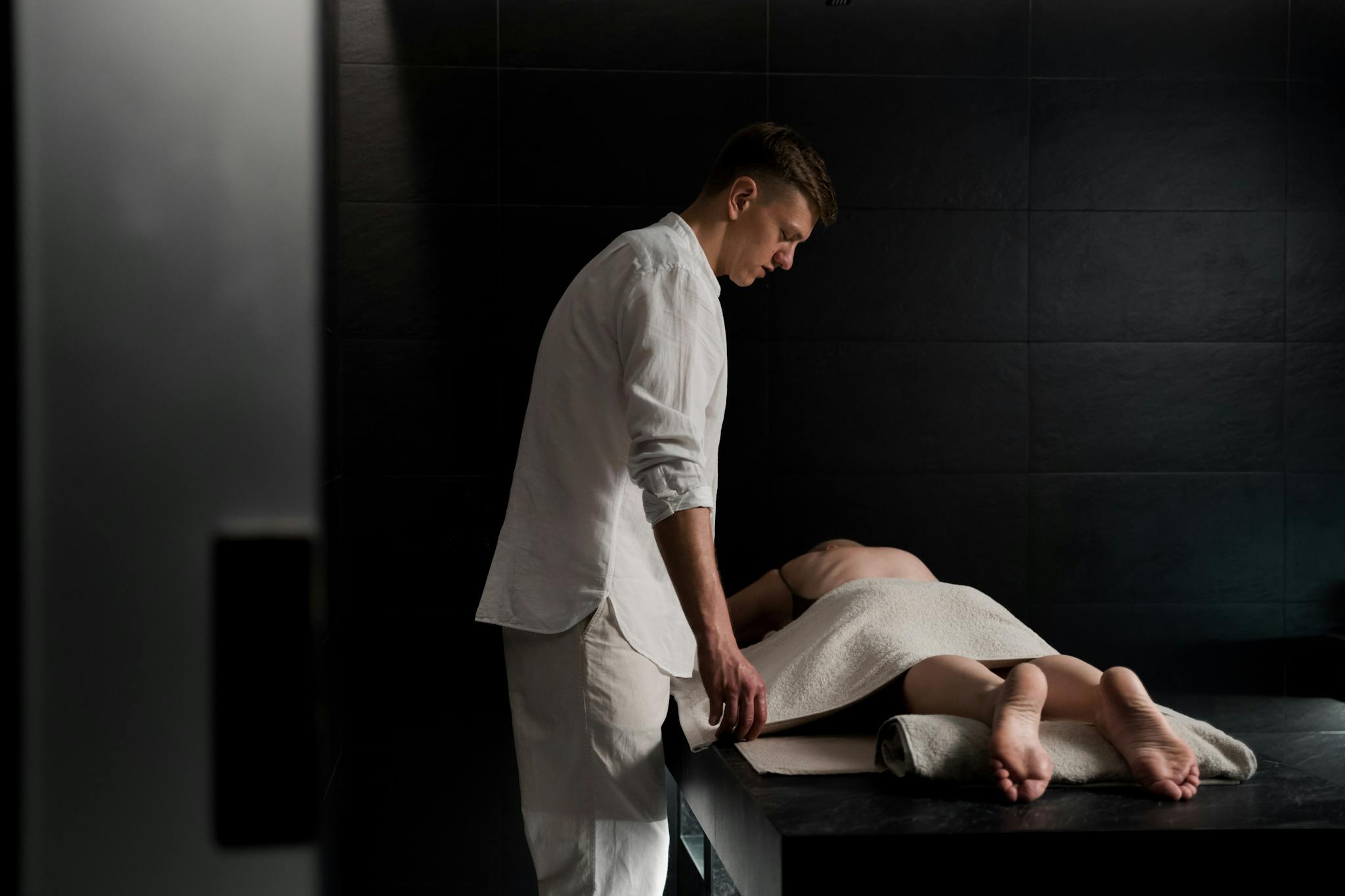 Therapist providing a relaxing massage in a serene spa setting, promoting wellbeing and relaxation.